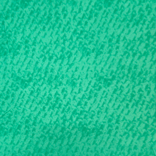 A close-up of a textured fabric or material swatch in a bright green colour with a fine, slightly mottled pattern.