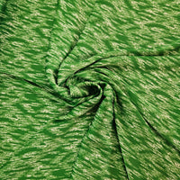 A close-up of a green fabric with a textured, heathered pattern, arranged in a spiral drape to show its texture and flexibility.
