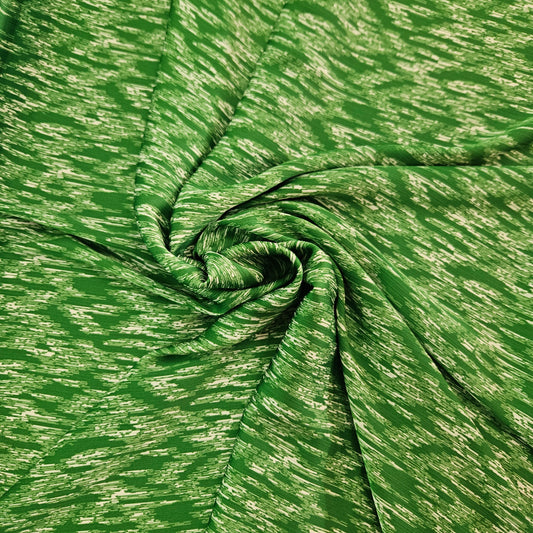 A close-up of a green fabric with a textured, heathered pattern, arranged in a spiral drape to show its texture and flexibility.
