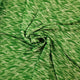 A close-up of a green fabric with a textured, heathered pattern, arranged in a spiral drape to show its texture and flexibility.