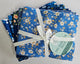 A bundle of folded patterned fabric squares tied with a white ribbon and a round paper tag that reads 'FAT QUARTER PACK,' photographed on a plain light background.