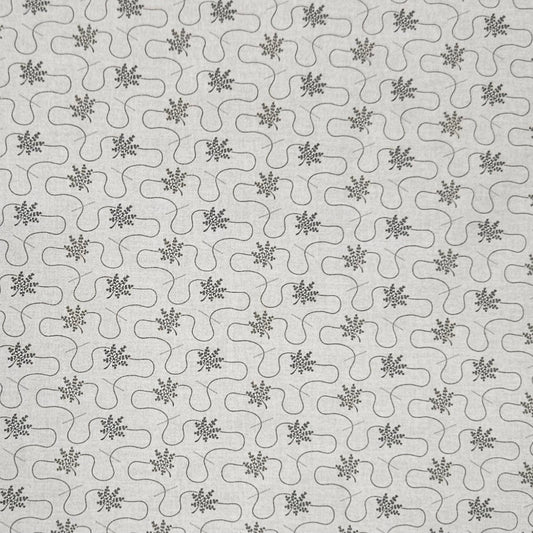 A close-up of a light gray fabric or material with a repeating dark gray wavy line pattern and small floral/starburst motifs.