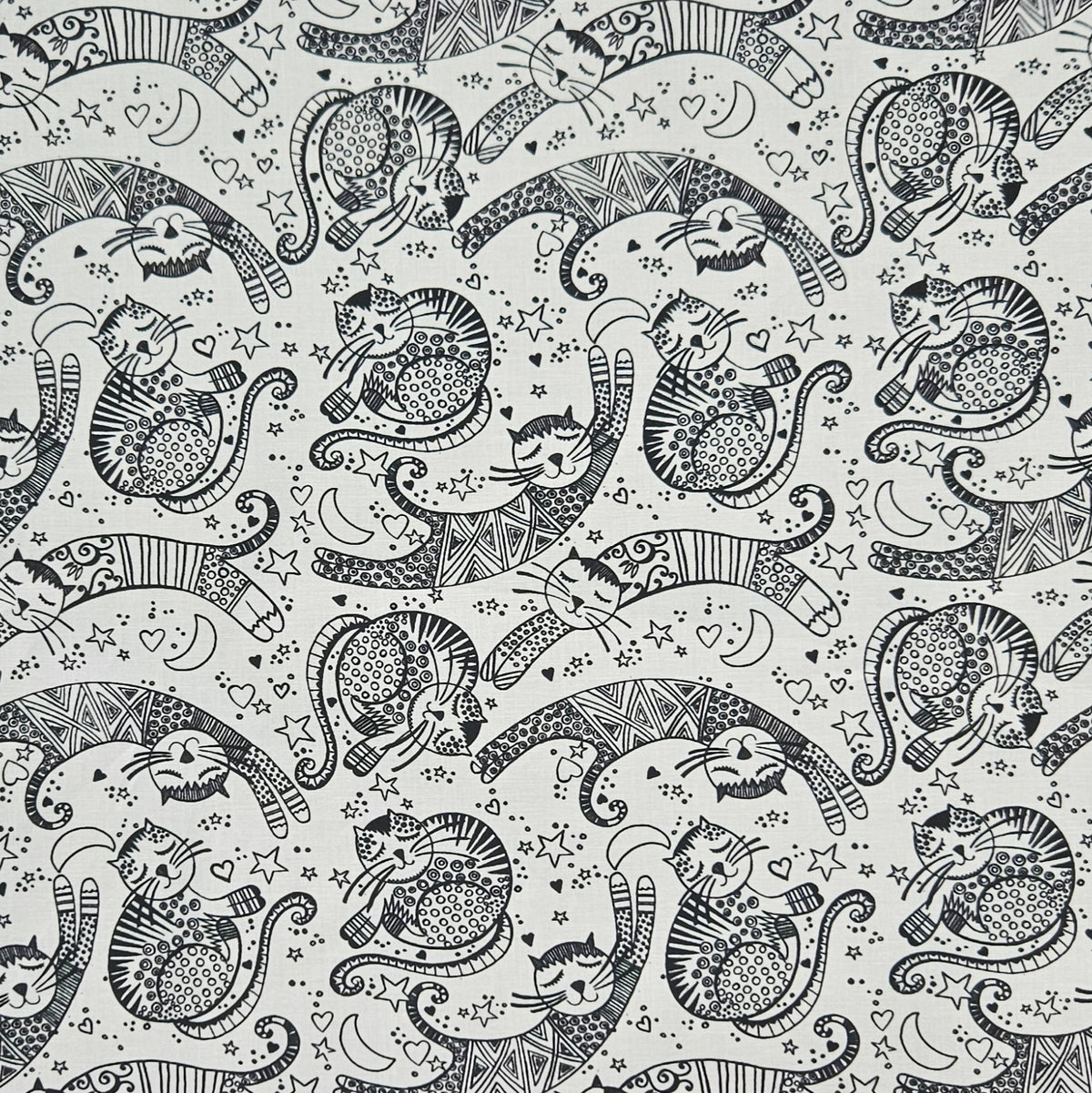 A seamless black and white pattern featuring whimsical cartoon cats in various playful poses, decorated with intricate doodle-style patterns, stars, hearts, and crescent moons.