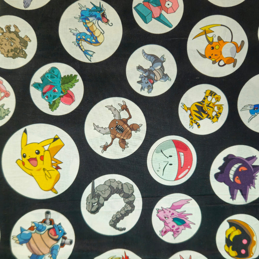 A close-up of a dark fabric featuring a repeating pattern of circular white patches, each containing a different colorful cartoon Pokémon character.