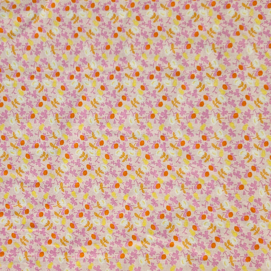 A close-up of a fabric pattern featuring small pink flowers, orange centers, and yellow-green stems on a light cream background.