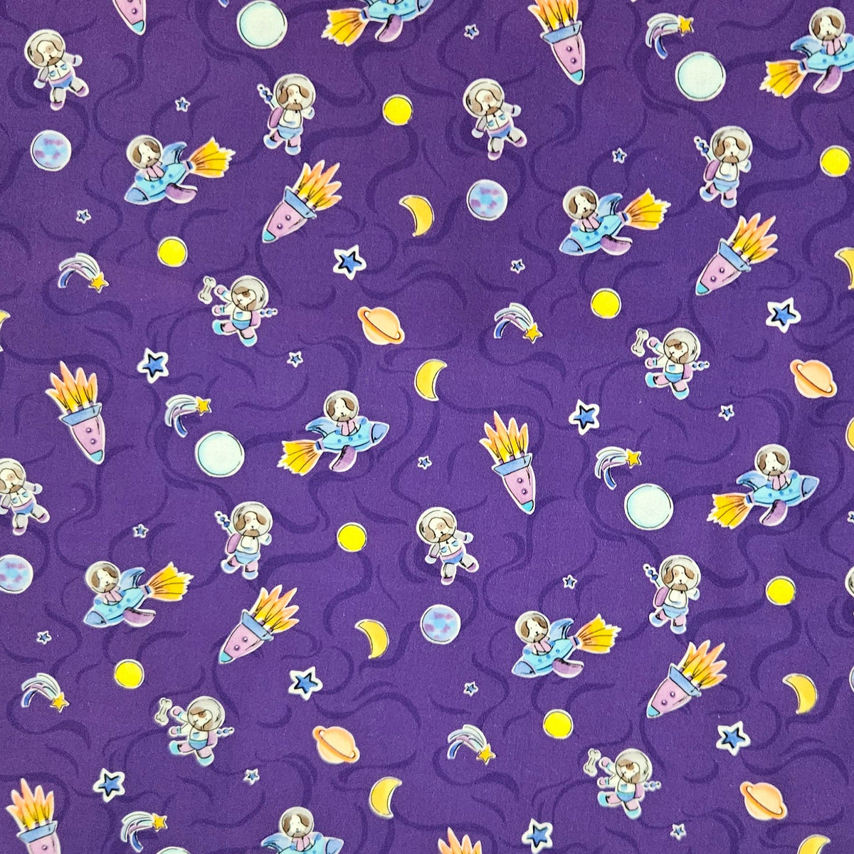 Purple fabric with a repeating cartoon space print featuring rockets, puppy astronauts, planets, stars, and crescent moons.